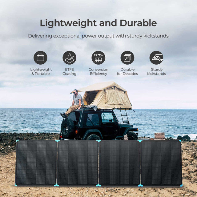 Solar panel on a beach with a person sitting on a vehicle and a tent in the background.