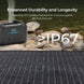 Portable power station with solar panel on a rocky shore, emphasizing durability and IP67 waterproof rating.
