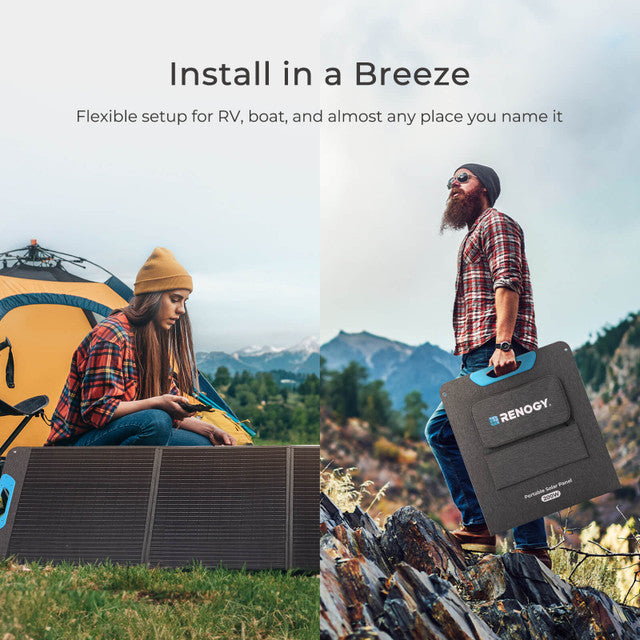 Two people with a Renogy portable solar panel in a mountainous outdoor setting.