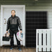 Man holding tools in front of a house with a solar panel on the wall.